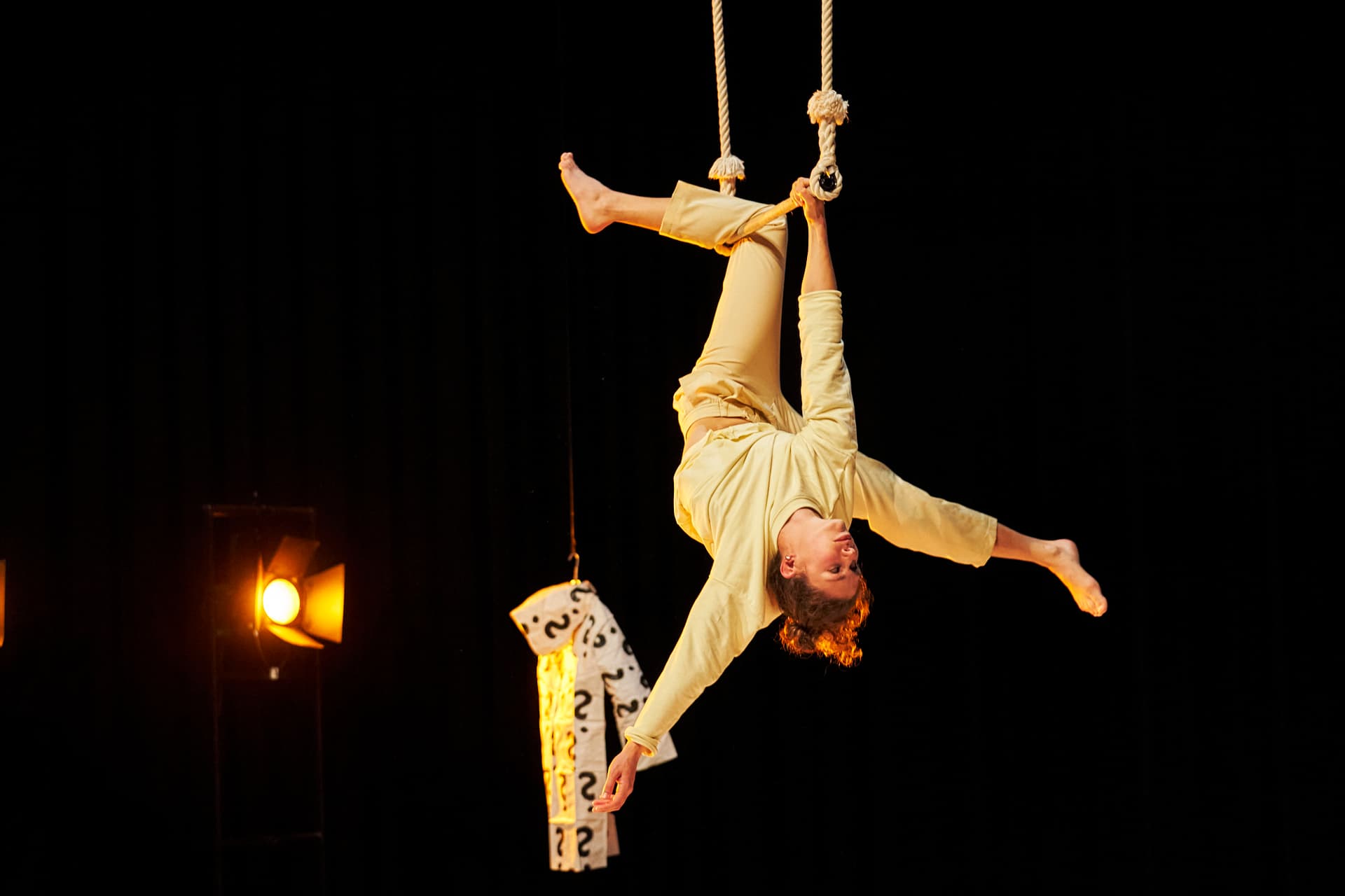 Eine Person hängt kopfüber von einem Seil.